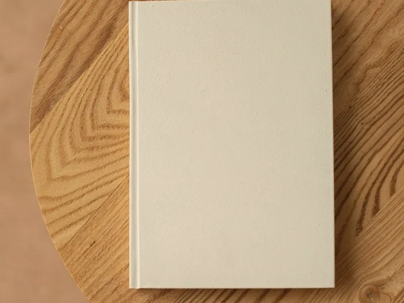 A closed hardback book on a wooden table