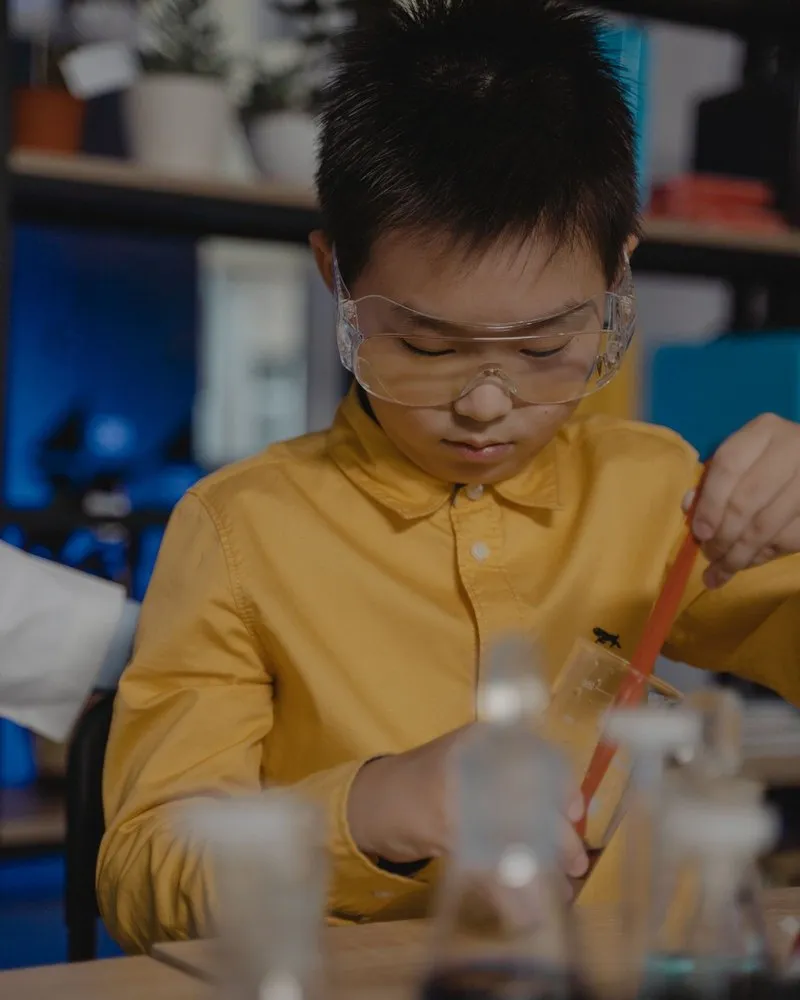 The boy, deep in concentration, works through his experiment